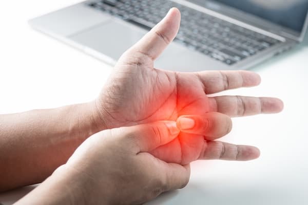 Woman holding painful finger