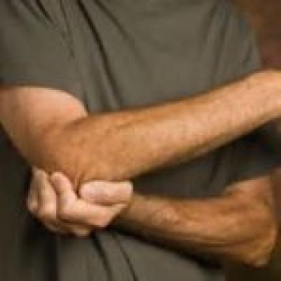 Man holding hurt elbow