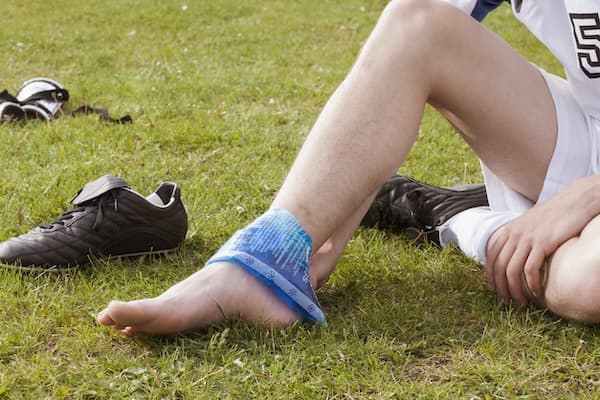 Soccer playing icing their ankle